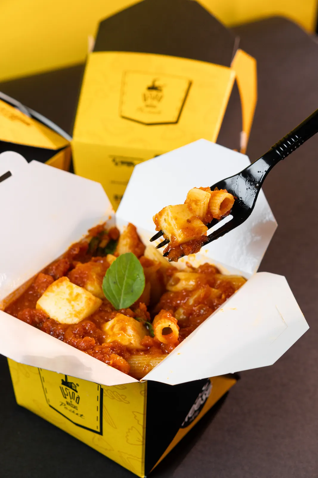 Massa ao sugo especial sendo servida da embalagem de delivery